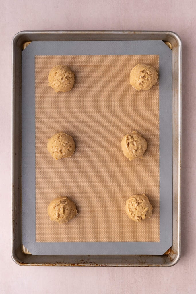 Butter crunch cookie dough on a lined baking sheet ready to bake in the oven.