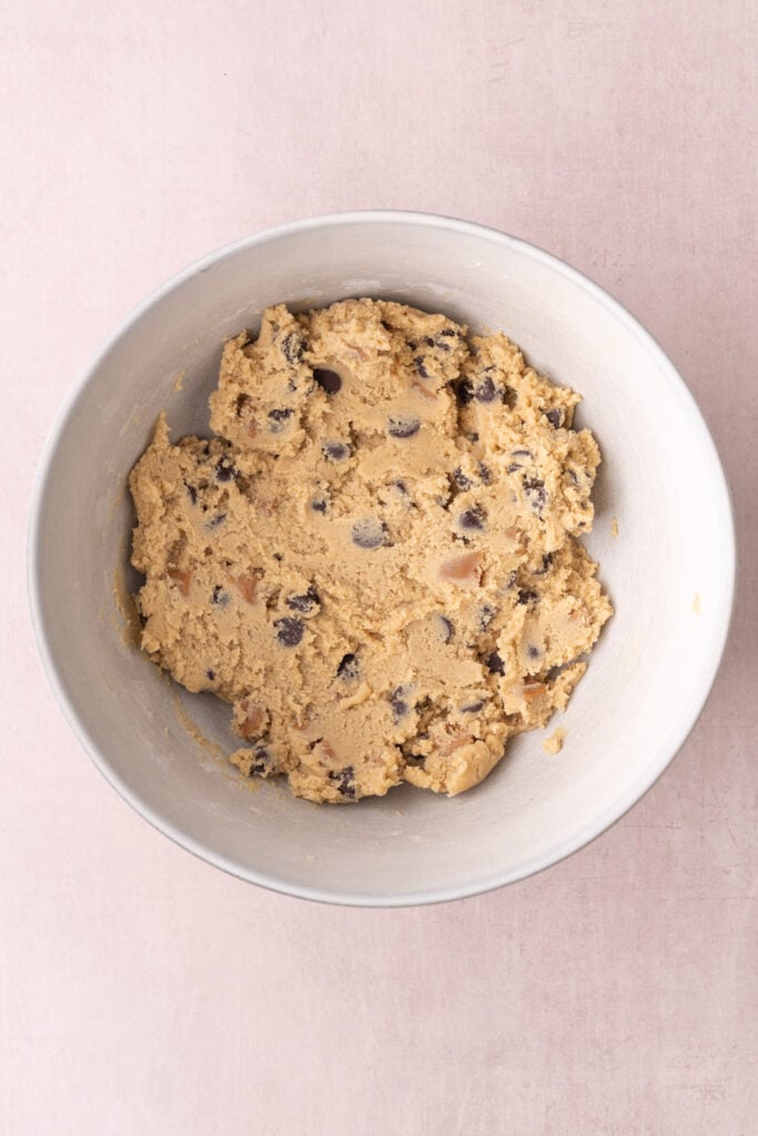 Cookie dough with a generous amount of chewy caramels and chocolate chips folded into it.