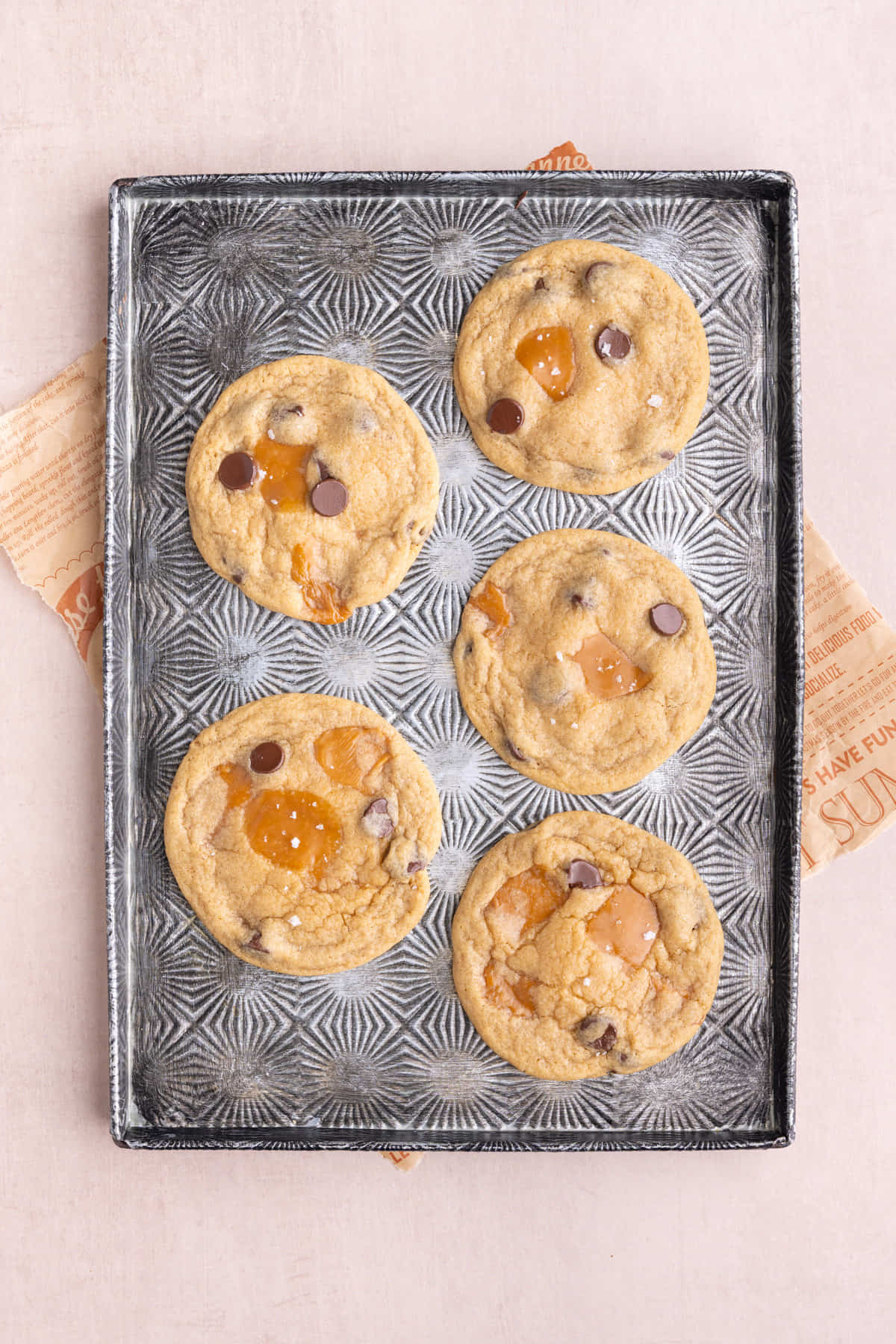 Overhead image of freshly baked caramel chocolate chip cookies on a tray.