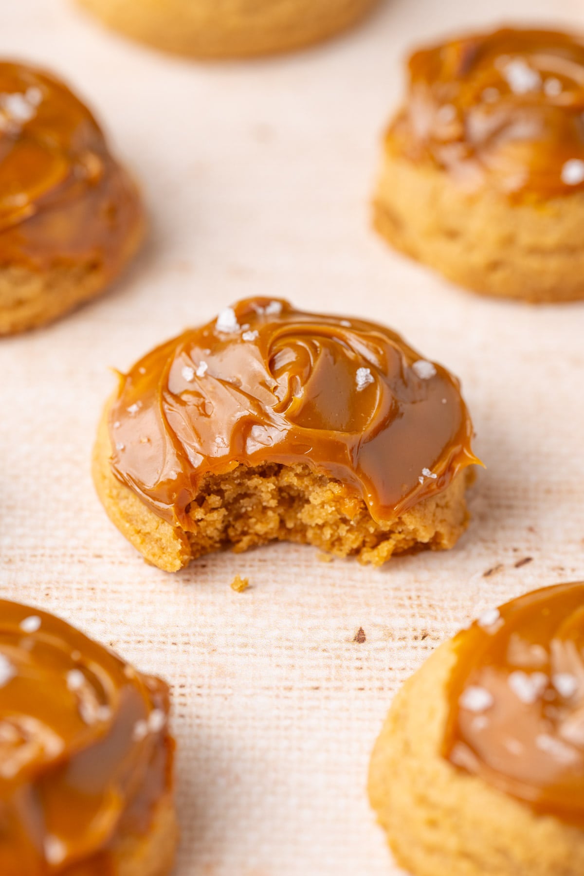 Soft and tender cookies topped with dulce de leche with a bite taken out of it.