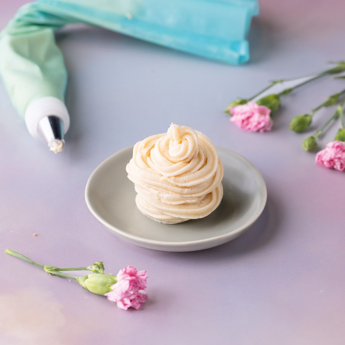 Brown butter cream cheese frosting piped in a pile on a small dish.