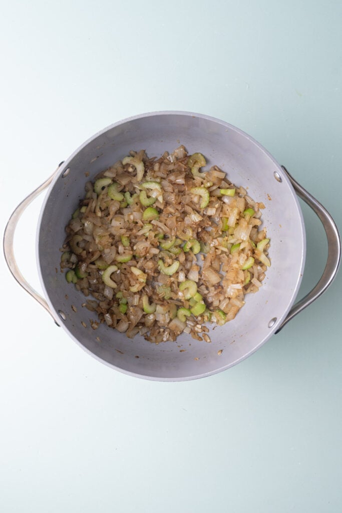 Cooking down onion, garlic, and celery in the same pot with butter that was used to sear salmon.