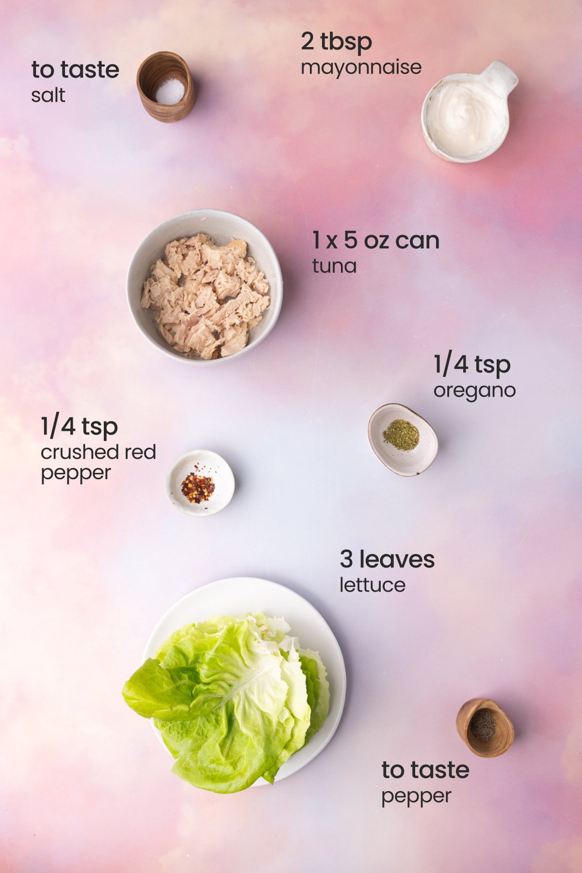 Overhead view of all the ingredients for tuna lettuce wraps - salt, mayonnaise, tuna, crushed red pepper, oregano, lettuce, and pepper.