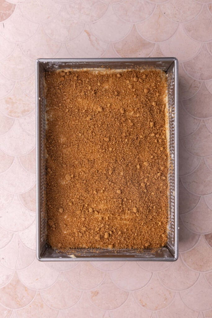 Cinnamon sugar layered on top of cake batter in a baking pan.