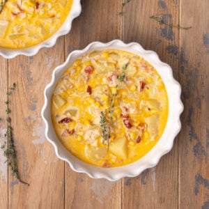 Creamy simple corn chowder in a shallow bowl with chunks of potato, sun-dried tomatoes, and a creamy broth.