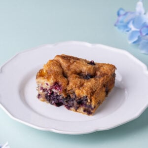 Piece of blueberry coffee cake on a white plate.