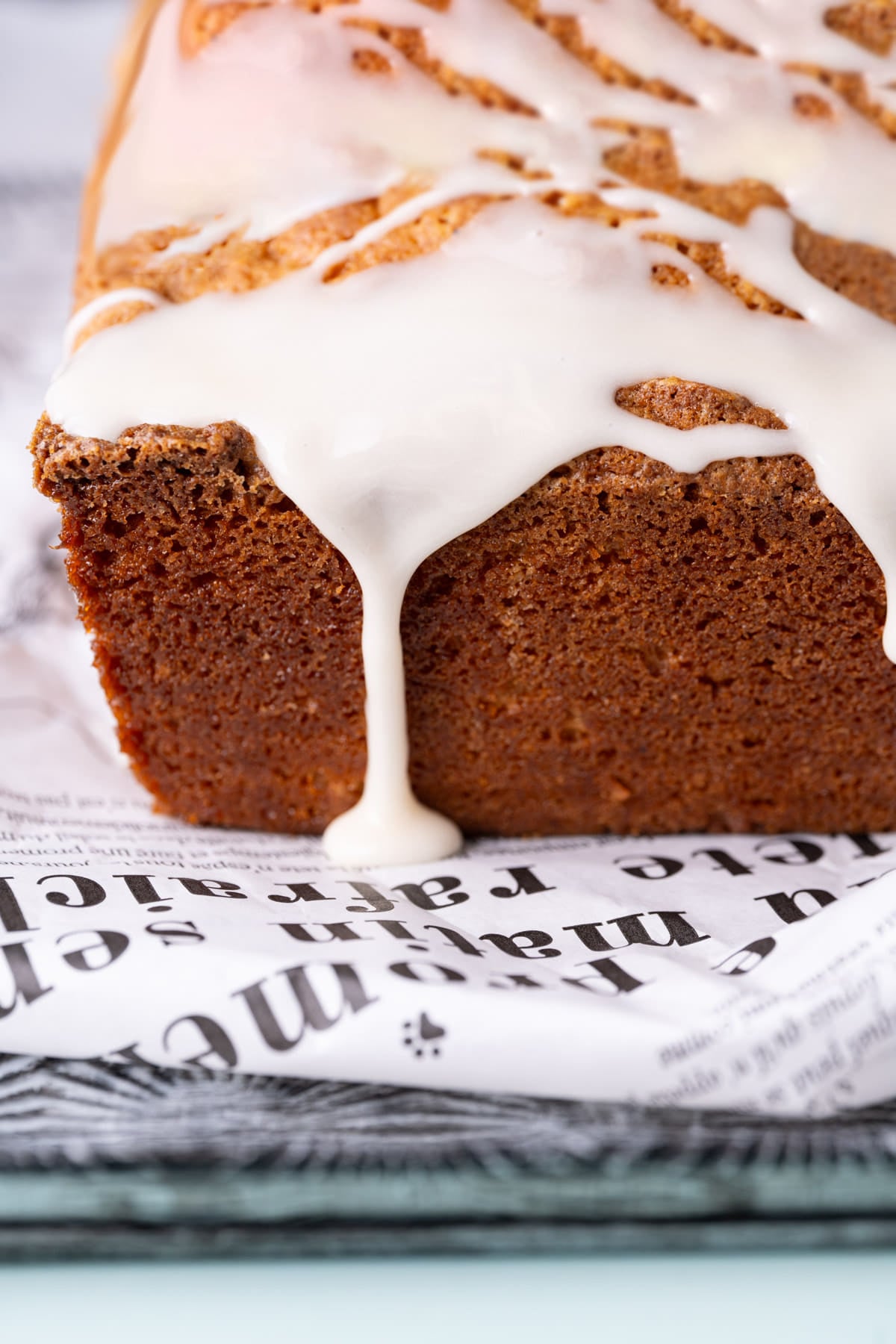 Close up of simple icing made with powdered sugar dripping off a pound cake.