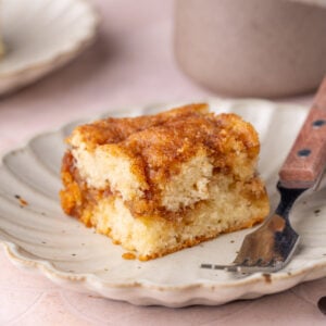 Piece of cinnamon sugar coffee cake on a plate with a fork.