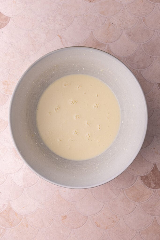 All the wet ingredients mixed together in a bowl for coffee cake, including the secret ingredient: sour cream.