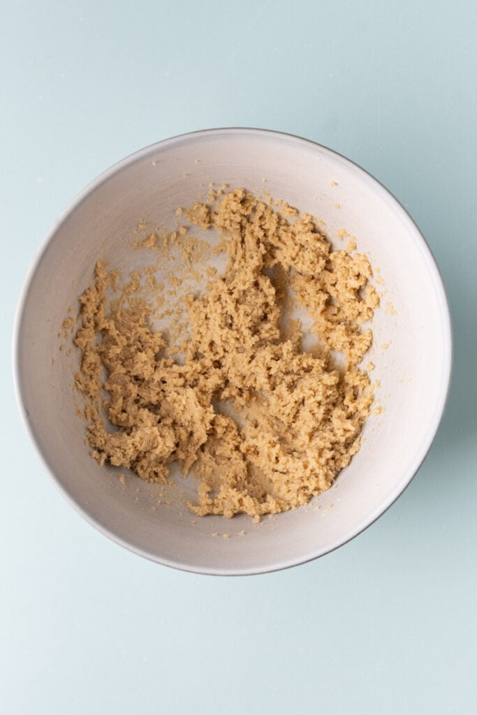 Brown sugar, and softened butter creamed together to form the base of a dough for cookie bars.