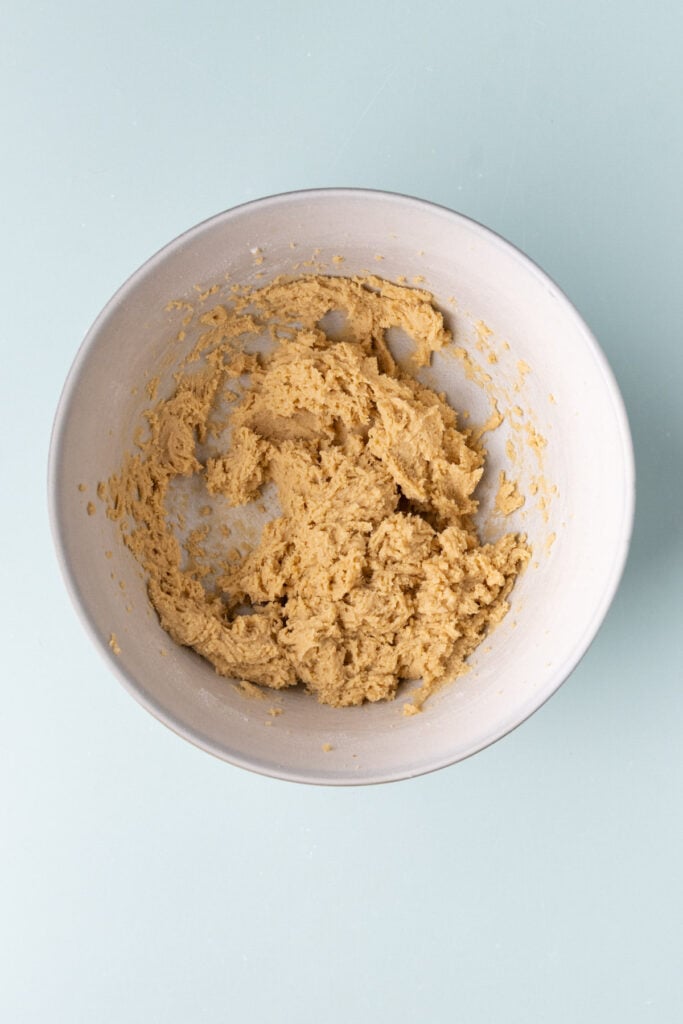 Buttery cookie dough in a large mixing bowl to make cookie bars.