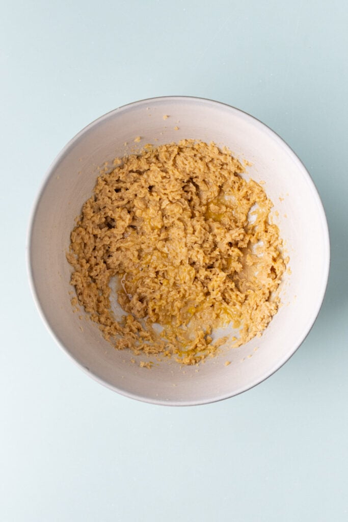 Vanilla extract and egg beaten into creamed butter and sugar to make cookie dough.