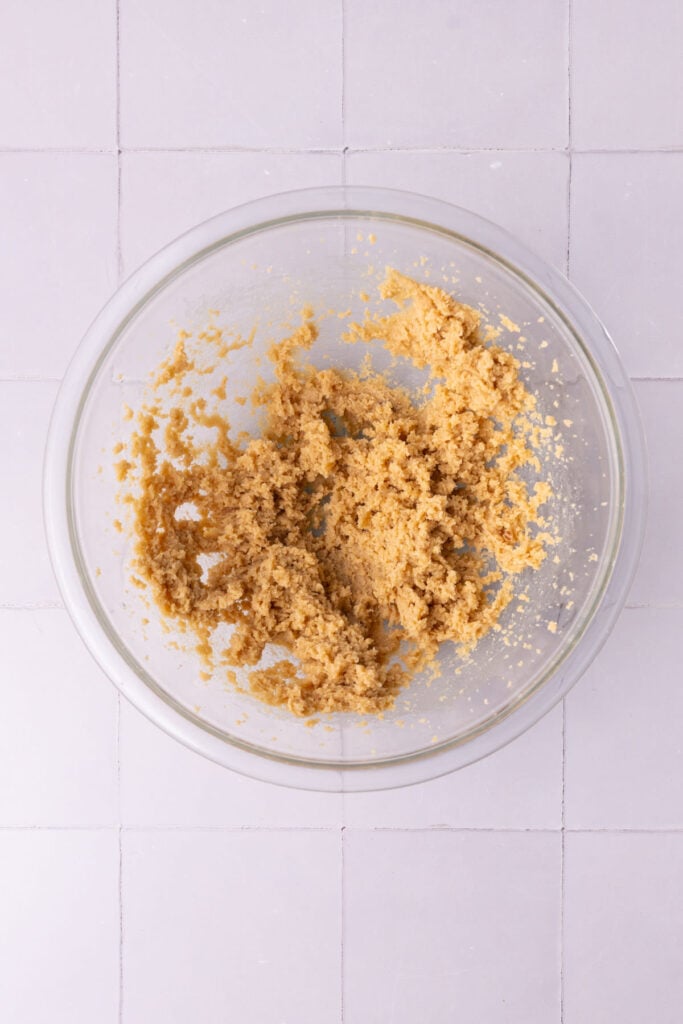 Softened butter and brown sugar creamed together until light and airy to form the base of a chewy cookie dough.