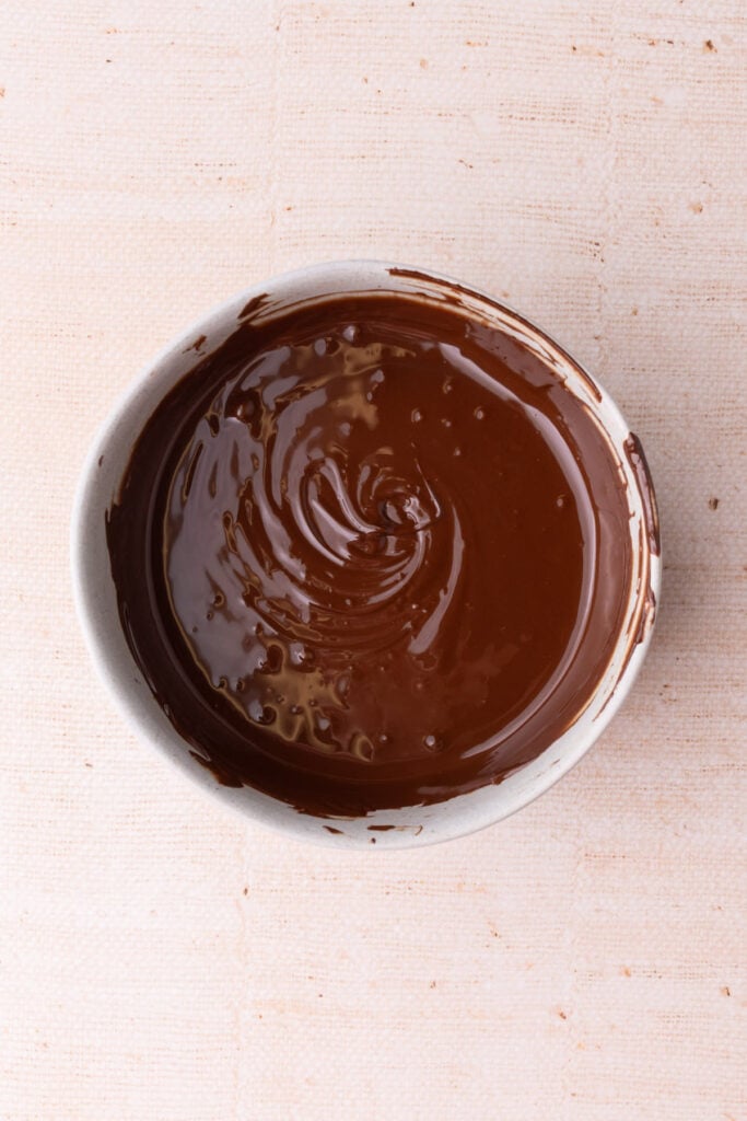 Chocolate chips melted down to liquid in a bowl.