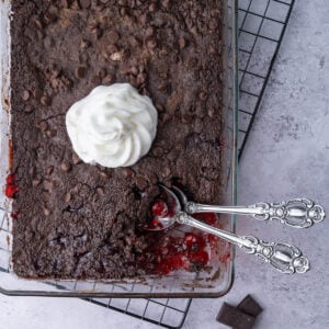 Close crop of chocolate cherry dump and bake cake with a serving scooped out to show the cherry pie filling underneath.