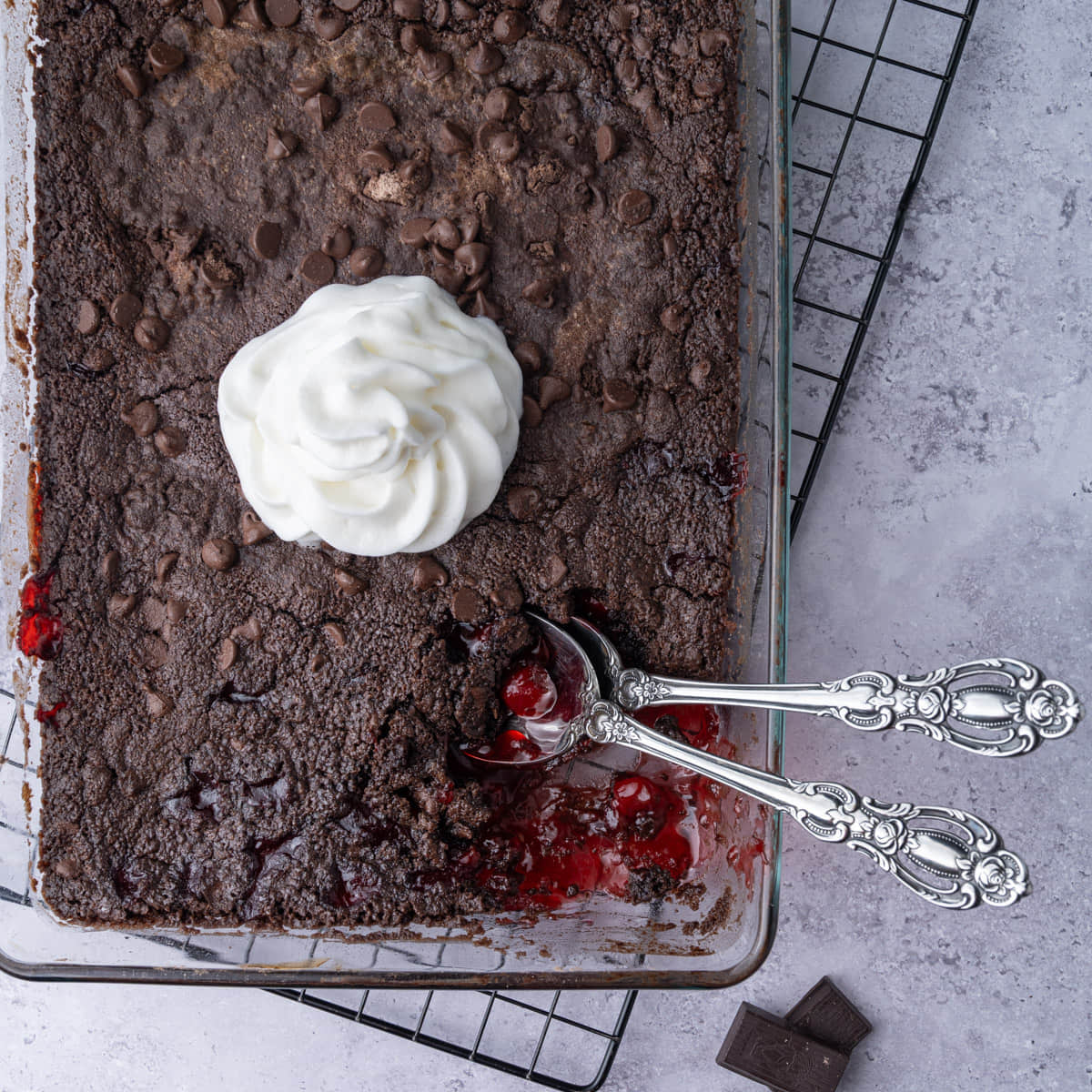 Close crop of chocolate cherry dump and bake cake with a serving scooped out to show the cherry pie filling underneath.