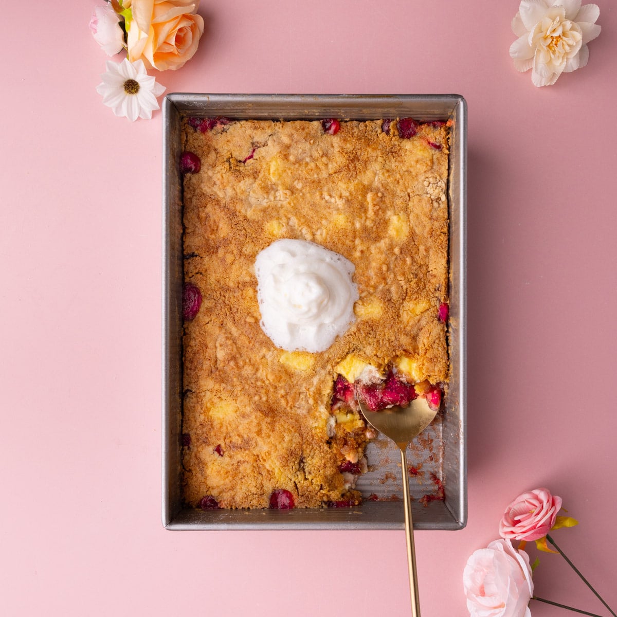 Strawberry cheesecake dump and bake cake with a serving scooped out to show layers.