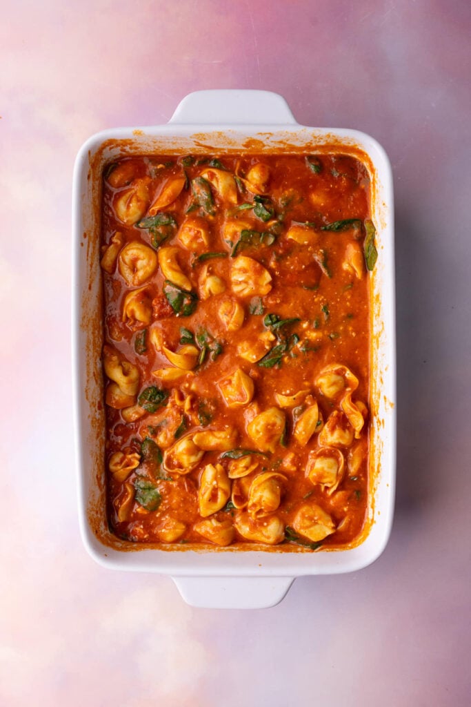 Cheese tortellini casserole halfway through baking.