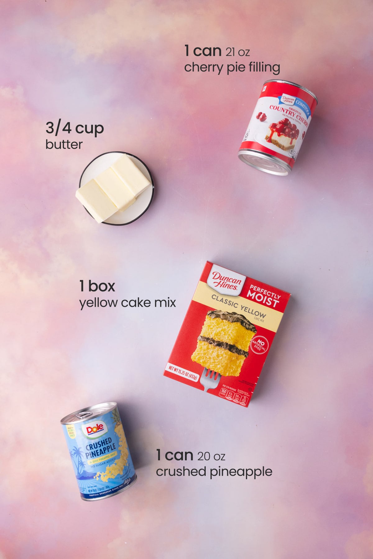 Everything you need to make a pineapple cherry dump cake including cherry pie filling, butter, cake mix, and crushed pineapple.