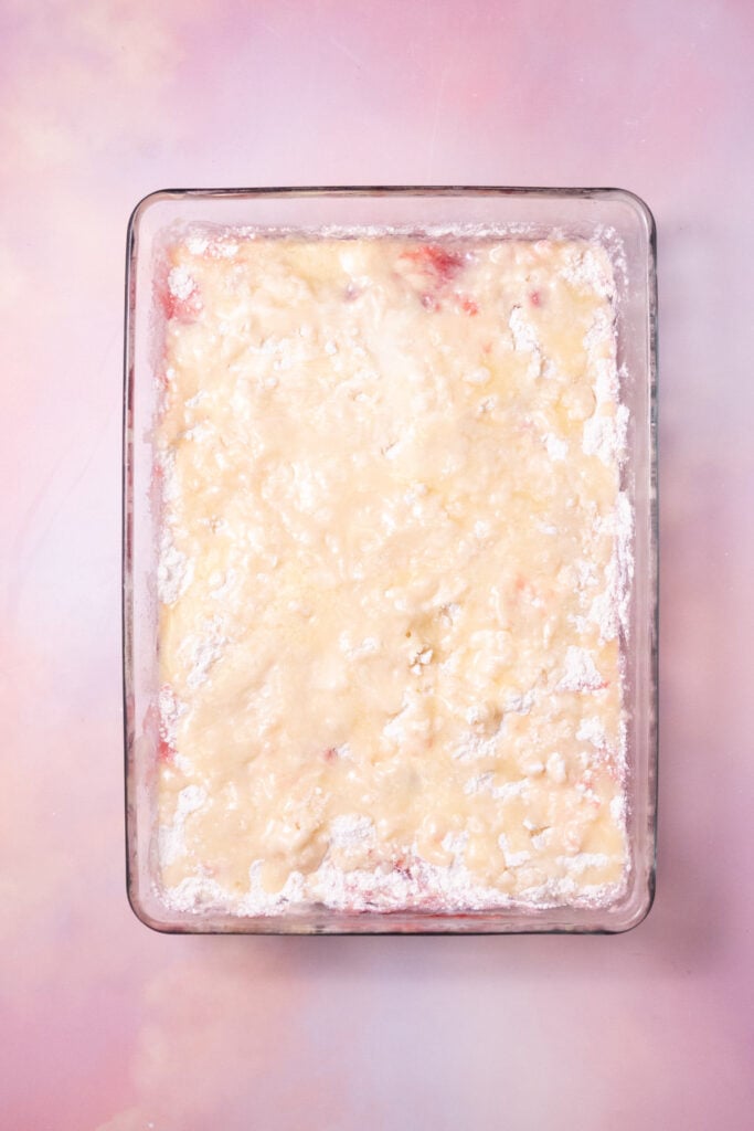 Melted butter poured over top boxed cake mix and fruit to make a dump cake.