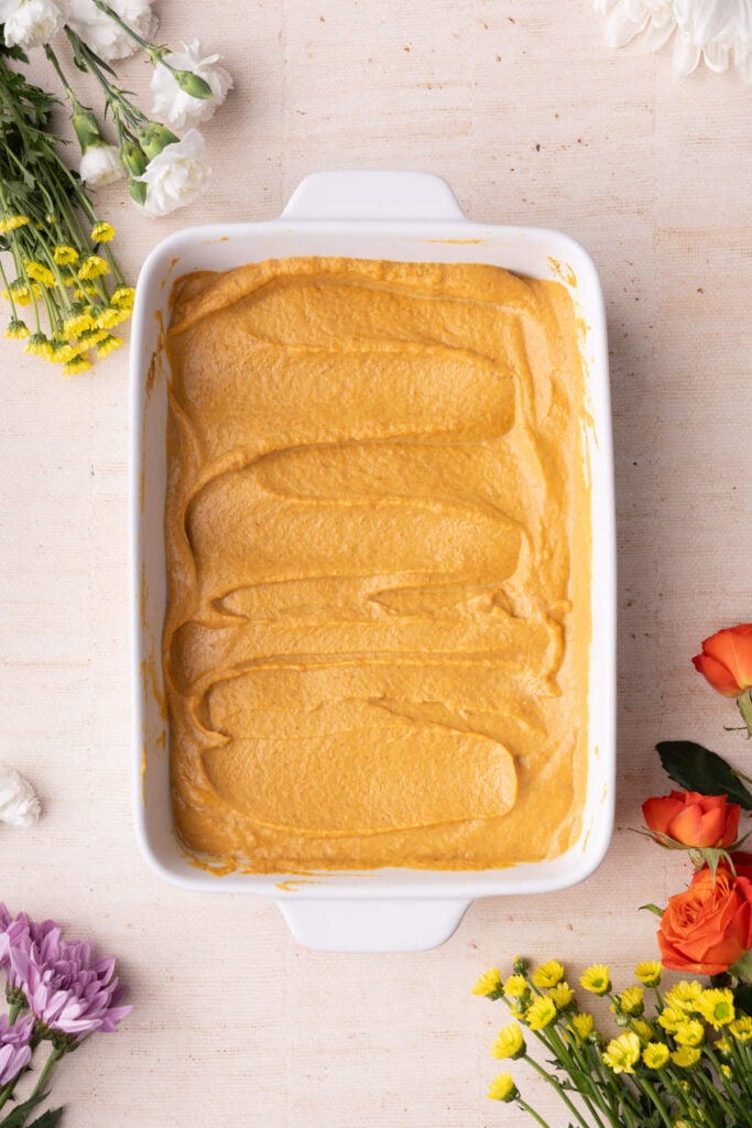 Pumpkin pie layer of dump cake ready to add yellow cake mix on top.