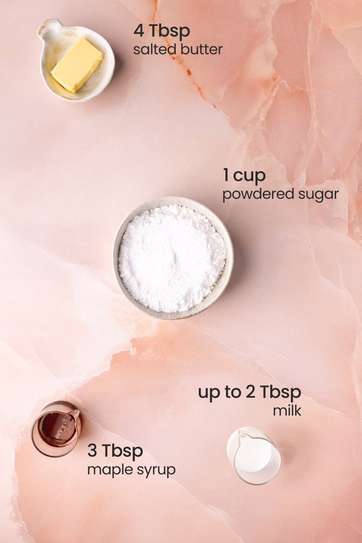 All ingredients needed for Maple Icing including salted butter, powdered sugar, pure maple syrup, and milk.