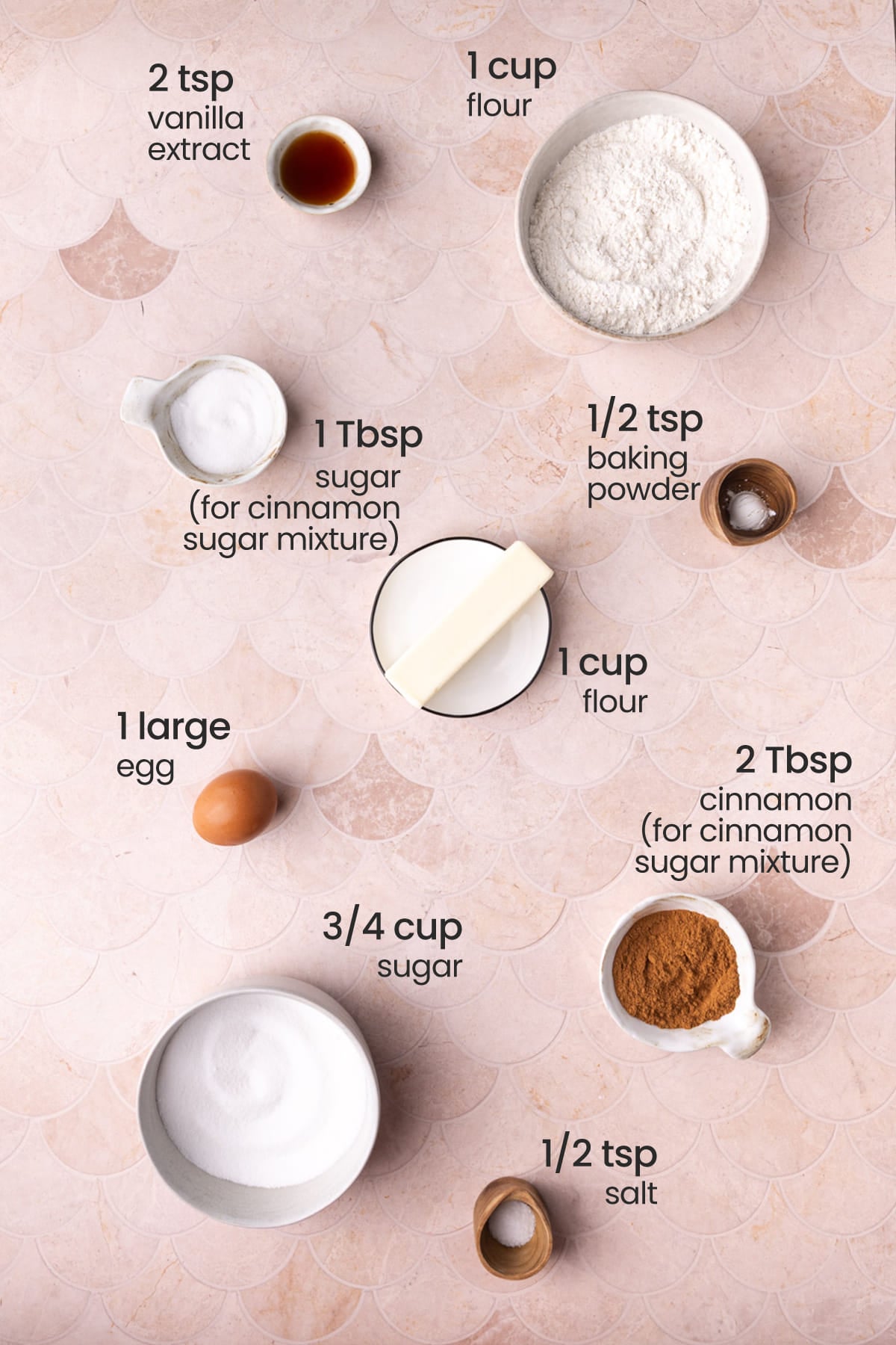 All ingredients needed for Snickerdoodles cookie bars including flour, vanilla extract, granulated sugar, butter, baking soda, egg, cinnamon, and salt.