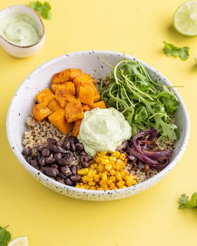 This Sweet Potato Quinoa Bowl with Avocado Crema hits the perfect balance of sweet and savory, with a subtle spicy kick. #quinoabowl #sweetpotato #avocadocrema #healthybowl #veganbowl #blackbeans #roastedcorn #healthylunch #healthydinner
