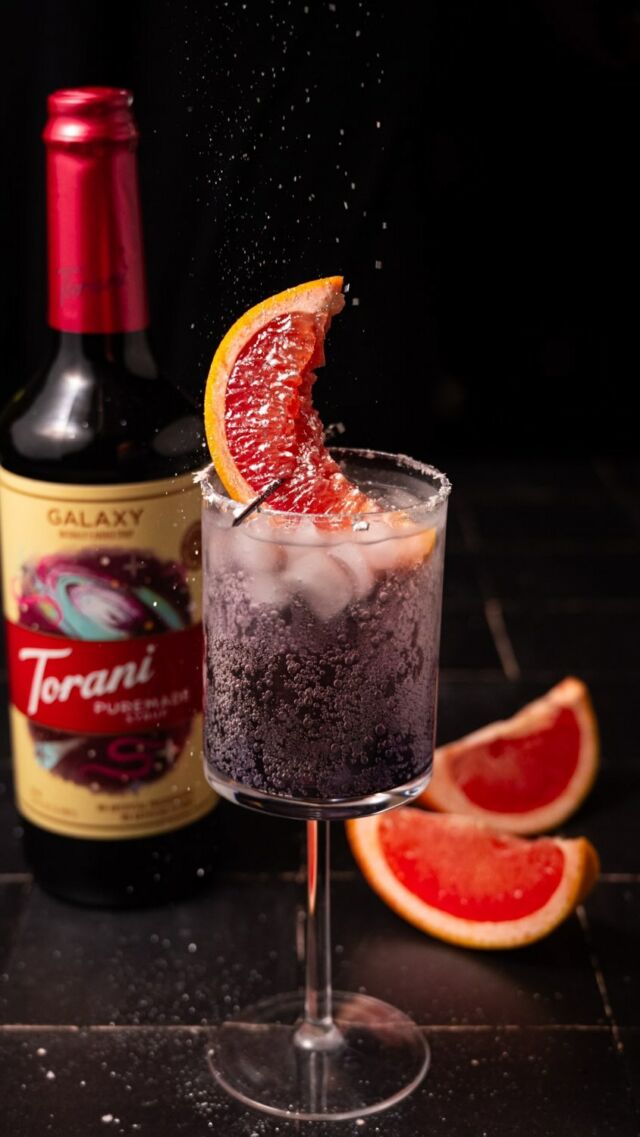 Looking for a fun and futuristic beverage? This 2 Ingredient Space Pop is all you need! #ad @worldmarket has an incredible selection of @torani syrups, including the 2024 flavor of the year Puremeade Galaxy Syrup. Puremade Syrups deliver amazing flavor with no artificial flavors or preservatives, using only colors from natural sources and no GMO’s and they mix so well to create endless beverage options! Torani Puremade Galaxy Syrup brings to life the molecular structure of dust clouds in space - which share the same flavor profiles as raspberries and dark rum. Combined with bubbly ginger ale, the flavor is totally out of this world! #galaxyatworldmarket
Space Pop Ingredients
-1 ounce @torani Puremade Galaxy Syrup
-4 ounces ginger ale
-grapefruit wedge and edible glitter for garnish (optional)
Method
-Pour Torani Puremade Galaxy Syrup and ginger ale over ice. 
-Slice a wedge of grapefruit to resemble a crescent moon and use it to garnish your drink. Finish off with edible glitter (optional). Enjoy!