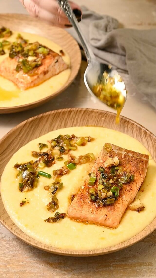 CREAMY CAJUN SALMON AND GRITS✨ Pan-fried salmon tops velvety grits that’ll transport your taste buds to the heart of the South. Bursting with flavor and only requires 30 minutes!

Creamy Grits
-½ cup quick grits
-2 cups vegetable broth
-⅓ cup milk (any dairy or unsweetened non-dairy)
-¼ cup medium or sharp cheddar cheese (~2 ounces)

-In a small pot fit with a lid, add the grits and vegetable broth and bring to a boil. Reduce heat to low and cover, simmering for 5-7 minutes until the mixture thickens.
-Then, turn the heat source off but keep the pot on the burner. Add the milk and cheddar cheese and whisk to combine, using the residual heat to melt the cheese.
-Split the creamy grits into two equal servings in a shallow bowl.

Cajun Salmon and Butter Sauce
-2 tablespoon olive oil
-10 ounces skinless salmon (in 2 individual 5 ounce portions)
-4 scallions, diced
-4 cloves garlic, minced
-1 tablespoon lemon juice
-2 teaspoons Cajun seasoning
-2 tablespoons unsalted butter

-To a large saucepan over medium heat, add the olive oil and get it hot for 2 minutes.
-Prep your salmon by using a paper towel to pat it dry.
-Add the garlic and shallots to the hot oil and carefully lower your salmon into the pan. With the salmon in the pan, add about half of the Cajun seasoning and lemon juice on top. Seasoning the salmon while it’s in the pan will ensure we make the most of both the Cajun seasoning and the lemon juice when we deglaze the pan later.
-Sear the salmon for 5 minutes and flip. Season the second side with the remaining Cajun seasoning and lemon juice. Sear for an additional 2-5 minutes on the second side.
-Flip the salmon one more time and use a spatula to quickly press the salmon into the pan, just to lock the seasoning onto the salmon. 
-Remove the salmon from the pan and place it right on top of the grits. Add the butter to the pan with the garlic, shallots, and excess seasoning and lemon juice to deglaze the pan.
-Drizzle the shallot and garlic butter on top of the salmon and grits and enjoy.