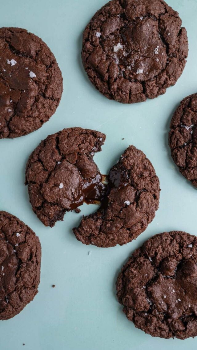 These chocolate fudge cookies are like molten lava cake in cookie form! A chewy chocolate cookie with a chocolate fudge sauce core.

Molten Chocolate Fudge
-⅓ cup dark chocolate chips
-2 tablespoons unsalted butter
-1 tablespoon milk

-To a microwave-safe bowl, add the chocolate chips, butter, and milk. Microwave on high for 30 seconds and whisk to combine. If you need a little more heat, you can microwave for an additional 10 seconds to bring everything together.
-Line a large baking tray with parchment paper or a reusable baking mat. Spoon 8 roughly equal sized dollops of fudge sauce onto the mat and place in the freezer for 1 hour, so you’re left with 8 chocolate coins.

Chocolate Fudge Cookies
-½ cup unsalted butter (½ cup butter = 1 stick)
-1 cup granulated sugar
-1 large egg
-1 teaspoon vanilla extract
-¾ cup all-purpose flour
-½ cup dark cocoa powder
-½ teaspoon baking soda
-¼ teaspoon salt

-Preheat your oven to 375°F and line two large baking sheets with parchment paper or a reusable baking mat.
-When your chocolate coins are almost frozen, it’s time to start on your cookie dough! To a large mixing bowl, add the softened butter and sugar. Use a hand mixer on high to cream together until light and smooth (about 3-5 minutes).
-Add the egg and vanilla extract and use your hand mixer on low to combine.
Add the flour, cocoa powder, baking soda, and salt and mix one last time. Use a spatula to scrape any flour off the sides of the bowl and integrate it into your dough.
-Use a large cookie scoop or 2 heaping tablespoons of dough to form 8 cookies, adding them to the prepped baking sheets. Leave at least an inch of space in between each cookie for minor spreading. You should have some leftover cookie dough.
-Now that your chocolate coins are frozen, use your hands to squish them and shape them into a sphere. Push each chocolate fudge sphere into the center of the cookie, then take a little extra cookie dough and cover it, so the fudge is completely encased by cookie dough.
-Bake on the top rack for 8-10 minutes until edges are firm. Allow to cool for at least 15 minutes. Enjoy!