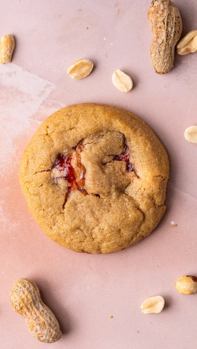 These nostalgic chewy peanut butter and jelly cookies take a quick and easy one bowl peanut butter cookie dough and stuffs it with jelly for a delicious and dynamic treat that will bring you back to your childhood.

Peanut Butter and Jelly Cookies
-½ cup unsalted butter, softened
-1 cup smooth creamy peanut butter
-1 cup light brown sugar (tightly packed)
-1 large egg
-1 teaspoon vanilla extract
-1 cup all-purpose flour
-1 teaspoon cornstarch
-½ teaspoon baking soda
-2 tablespoons jelly (any works, I used grape)

Method
-Preheat your oven to 350°F and line a large baking sheet with a reusable baking mat or parchment paper.
-In a large mixing bowl, use a hand (or stand) mixer on high to cream together the butter, peanut butter, and sugar until well-combined and smooth.
-Add the egg and vanilla extract and mix again to combine.
-Mix in the flour, cornstarch and baking soda. Use a rubber spatula to scrape any dry ingredients stuck to the sides or bottom of the bowl and integrate.
-Use a large cookie scoop (or 4 tablespoons of dough) to portion your cookie dough. Line the cookie dough balls up on your prepared baking sheet, leaving space in between each one.
-Use your thumb to press down the middle of each cookie, so you’re left with an indent in the center of each dough ball.
-Fill each indent with ½ teaspoon of jelly.
-Wet your hands (this will make it easier to work with the sticky dough) and fold the peanut butter dough over the jelly, then roll the cookie in between two hands so that you’re left with a round peanut butter cookie with a jelly center.
-The jelly must be completely encapsulated, if you need to grab a little extra cookie dough to achieve this, feel free to!
-Bake on the top rack of the oven for 14-16 minutes. Allow them to cool completely so that the jelly has a chance to solidify before diving in. Enjoy!